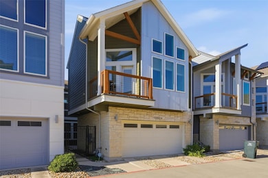 View of front of house featuring stone siding, a balcony, and an attached garage