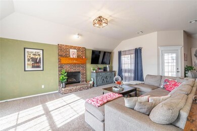 Living room with brick fireplace, vaulted ceiling,