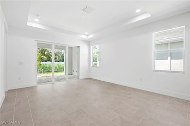 Great room living area with tray ceiling and slidi