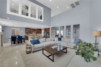 Living area featuring a towering ceiling, arched w