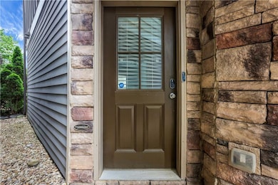 View of exterior entry featuring stone siding