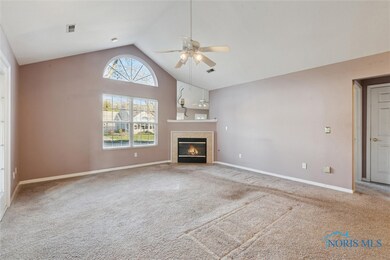 Living room has corner gas fireplace, ceiling fan
