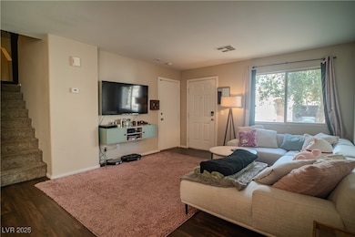 Living area featuring stairs, dark wood-type floor