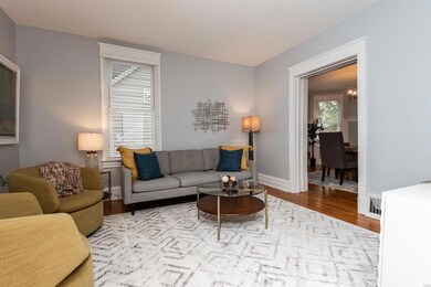 Lovely living room with gorgeous hardwood, big windows, extra tall base, moldings and trim!
