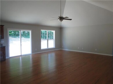 Great room with cathedral ceiling, ceiling fan and hardwood flooring