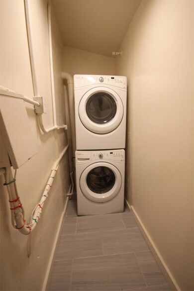 Laundry room with estacked washer and dryer and b