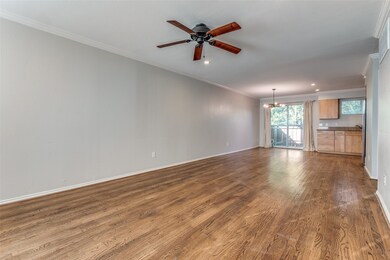 Unfurnished living room with crown molding, hardwood / wood-style flooring, and ceiling fan with notable chandelier