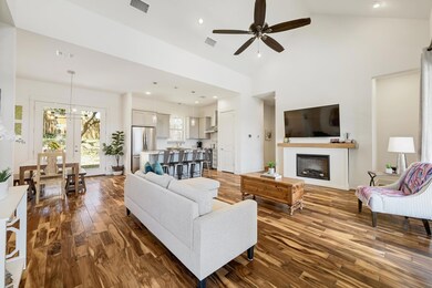 Living room with ceiling fan, dark wood-type floo