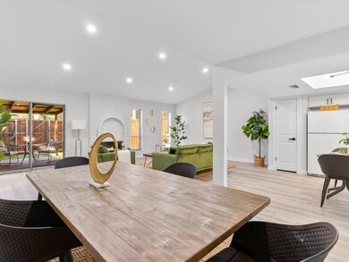 Dining room featuring vaulted ceiling with skyligh