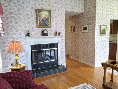 Open living/dining room with hardwood floors.  Gas