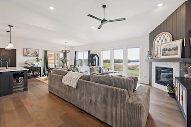 Living area featuring recessed lighting, gas fireplace, engineered hardwood floors, healthy amount of natural light, and lofted ceiling