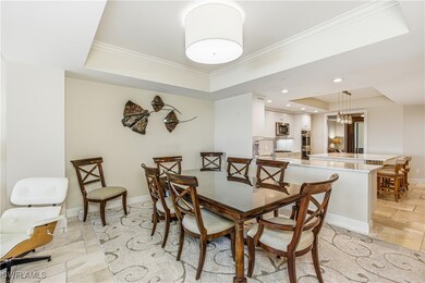 Dining room featuring a raised ceiling, stone tile flooring, and ornamental molding