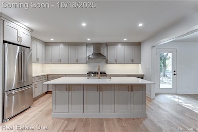 Kitchen with high end fridge, light wood-style floors, backsplash, recessed lighting, and gray cabinets