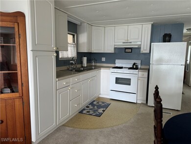 Kitchen with sink, light carpet, white appliances,