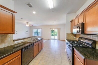 Kitchen featuring a sink, black appliances, brown