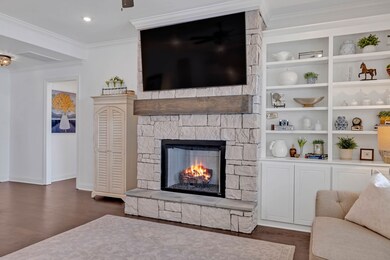 Another view of your Living Room shows the custom built-in cabinetry and shelving along with the stacked stone fireplace and wood mantle!