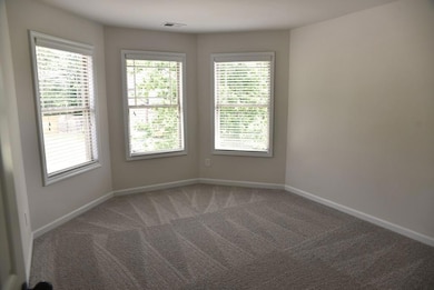 Carpeted spare room with baseboards