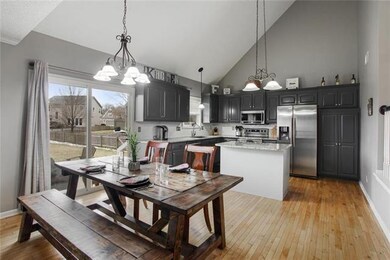 The eat-in kitchen has hardwood floors, a door lea