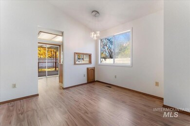 Empty room with light wood-style floors and a chandelier