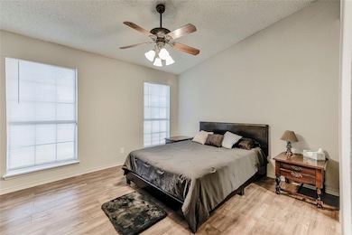 Bedroom featuring a textured ceiling, light hardwo