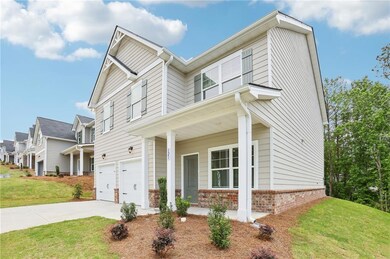 View of front of house featuring an attached garage, a front yard, driveway, and brick siding