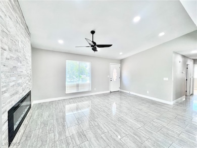 Unfurnished living room featuring a fireplace, a ceiling fan, wood tiled floors, and recessed lighting