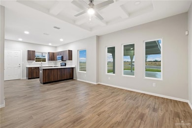 Kitchen featuring stainless steel appliances, light hardwood / wood-style flooring, ceiling fan, and coffered ceiling