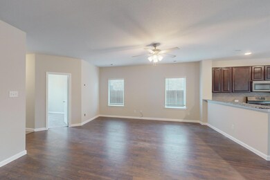 Unfurnished living room featuring ceiling fan and 