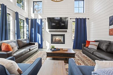 Living room featuring a high ceiling and a firepla