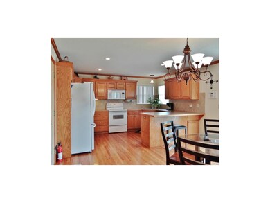 The kitchen offers wood flooring, a dining area wi