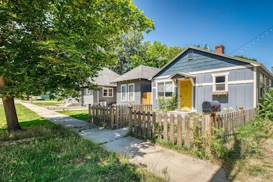 Bungalow-style home featuring a chimney and a fenced front yard