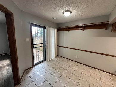 Spare room with a textured ceiling and baseboards