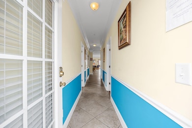 Hallway featuring crown molding and light tile patterned floors