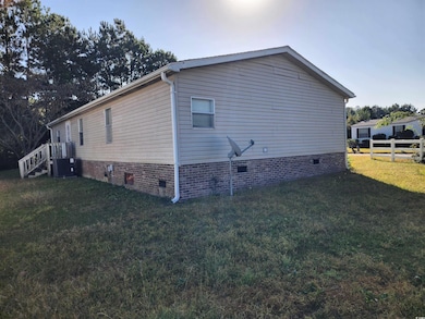 View of side of home with cooling unit and a yard