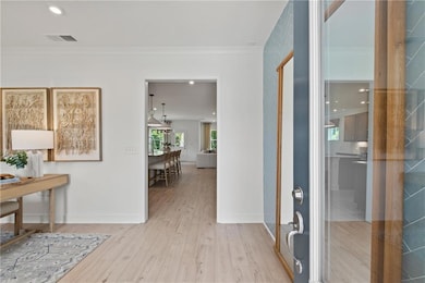 Corridor featuring crown molding, wood finished floors, and baseboards