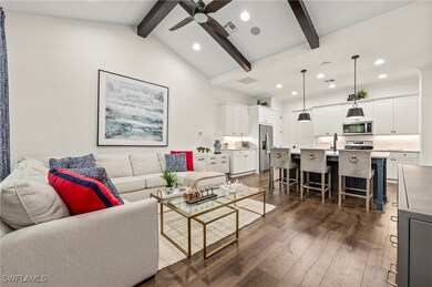 Living room with sink, ceiling fan, dark wood-type