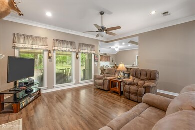Living room with crown molding, ceiling fan, and l