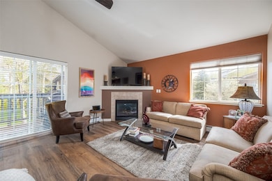 Living room with a fireplace, ceiling fan, and hig