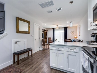 Kitchen featuring white cabinets, a peninsula, de