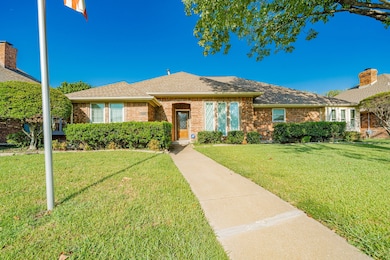 Single story home with a front yard, roof with shingles, and brick siding