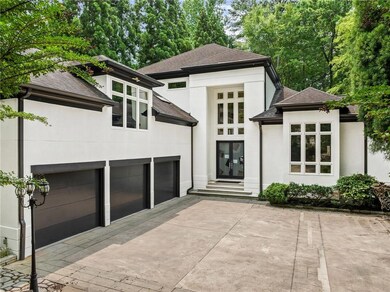 View of front of home with stucco siding, concrete driveway, a shingled roof, and an attached garage