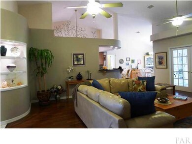 The bookshelves are lighted for accent and the floor is a beautiful hardwood. Also, an open concept to the kitchen.