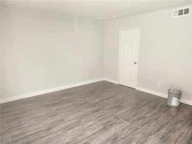 Spare room featuring dark wood-style floors and ba