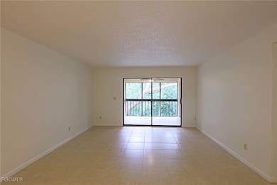 Unfurnished room with a textured ceiling and light tile patterned floors