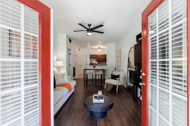 Living room with crown molding, ceiling fan, and d
