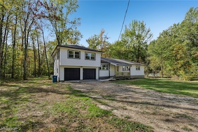 Tri-level home with driveway, a front yard, and an attached garage