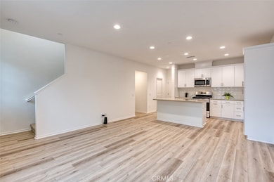 Open concept living room and kitchen with quartz counters, breakfast bar island and custom cabinetry.