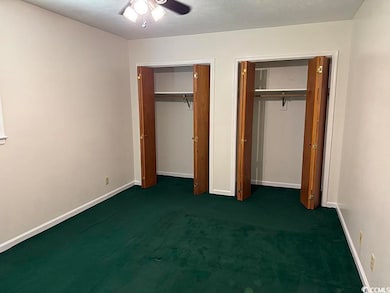 Unfurnished bedroom featuring multiple closets, carpet floors, and ceiling fan