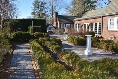 Garden includes boxwood shrubberies with tile walk