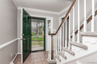 Foyer with ceramic tile flooring & crown/chair mou